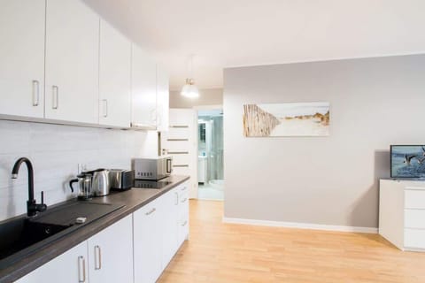 A different view of the kitchen, showing additional storage and countertop space. The black and white contrast gives it a contemporary feel.