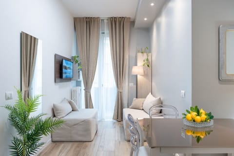 Living room with fully equipped kitchen, dining table, and sofa for a relaxing and practical stay
