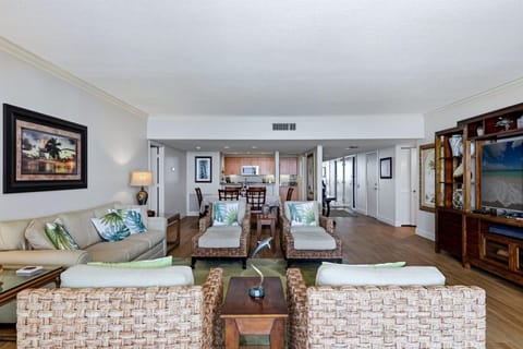 Sink into plush wicker seating with tropical accents while enjoying your open-concept living space, complete with modern kitchen and elegant dining area.