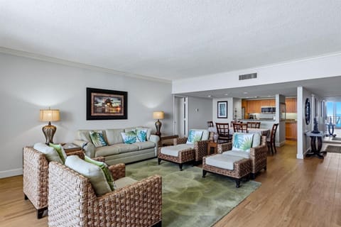 Unwind in your spacious tropical-inspired living room, where wicker chairs and palm-printed pillows create a resort atmosphere. The open layout connects seamlessly to your dining area and kitchen.