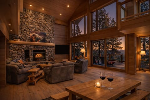 Warm evening living space with fireplace glow and sunset views.