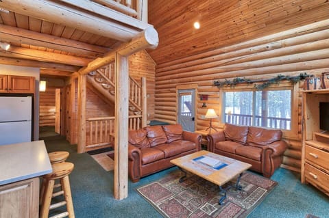 Unwind in the roomy living space with comfy leather seating, a chic wooden coffee table, and a modern TV setup.