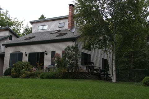 Front has expansive lawn (5,000 sf) and slopes gently down to the woods.