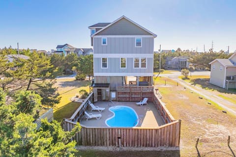Coastal retreat featuring private pool surrounded by natural dunes and sea oats in peaceful beach community.