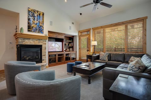 Sink into plush seating by your crackling fireplace, where warm wood tones and mountain views create the perfect retreat for cozy evenings together.