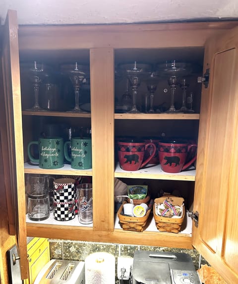 Assortment of mugs, glassware, Kcups, coffee filters, tea, and sugar ammenities