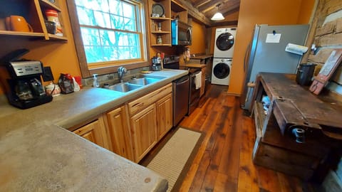 Fully stocked kitchen with unique antique counter and a stacked washer and dryer