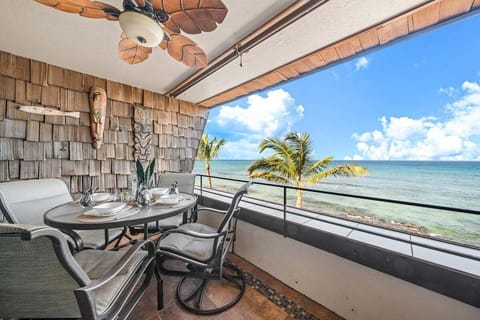 Oceanfront lanai with seating for four, ideal for meals with Maui sunset views.