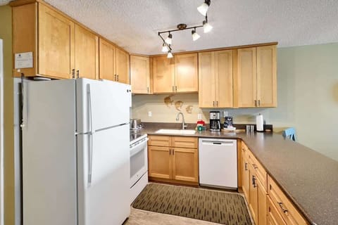 The kitchen has full-size appliances including a fridge, stove, and dishwasher