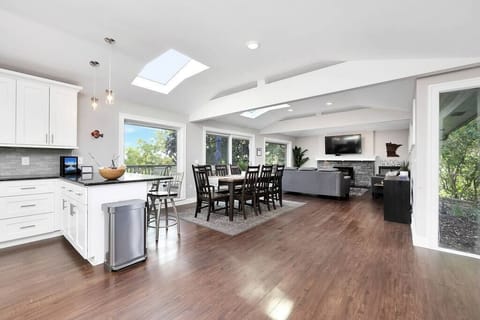 This home was designed with an open floor plan and large windows and skylights. Main level living room, dining room and kitchen are connected to an enormous deck: the perfect layout for hosting an event or team outing.