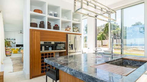 The fully equipped kitchen boasts state-of-the-art appliances, ensuring a seamless self-catered stay, while the adjacent island makes an ideal spot for your morning coffee.