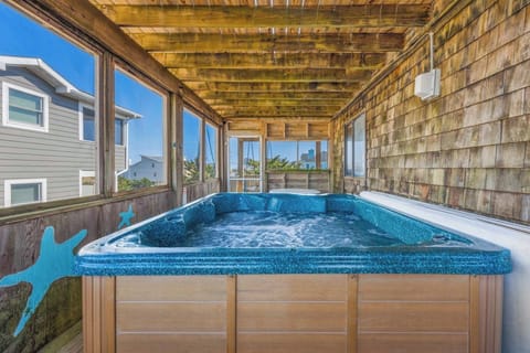 Slip into your private hot tub on this enclosed porch, where warm bubbles and ocean breezes await. Rustic cedar walls and panoramic windows frame your peaceful escape—unwind under the sun by day or stars by night.