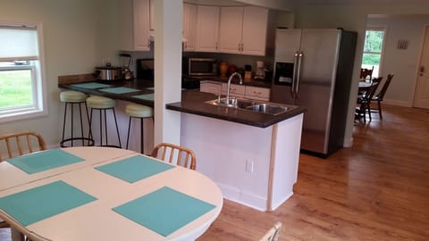 Kitchen is open to both dining room and back patio with eat-in outdoor kitchen.