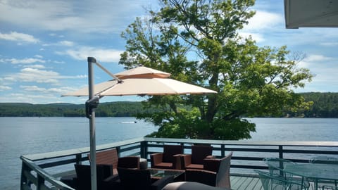 Large deck overlooking the lake w/ plenty of furniture and  cantilever umbrella