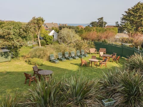Sunny Garden with Tables, Chairs and Sun Loungers