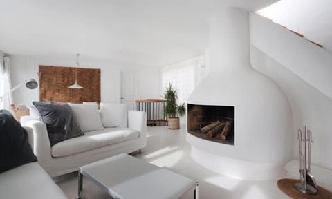 The 50m2 main living with fireplace. Stair to roof terrace