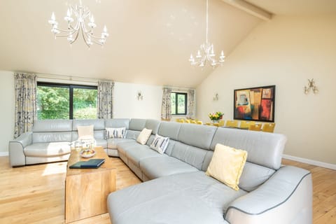 Open plan living area with 10 seater sofa and 10 seater dining table. 