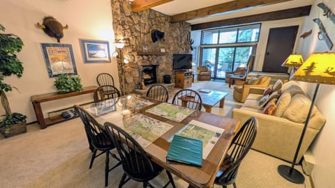 Living room with dining table, sofa bed, wood fireplace, and balcony w/ gas BBQ
