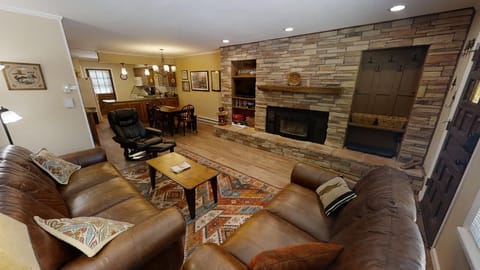Unwind in this inviting living space where plush leather seating faces a warm stone fireplace. The open layout flows seamlessly into the dining area, perfect for gathering and making memories during your stay.