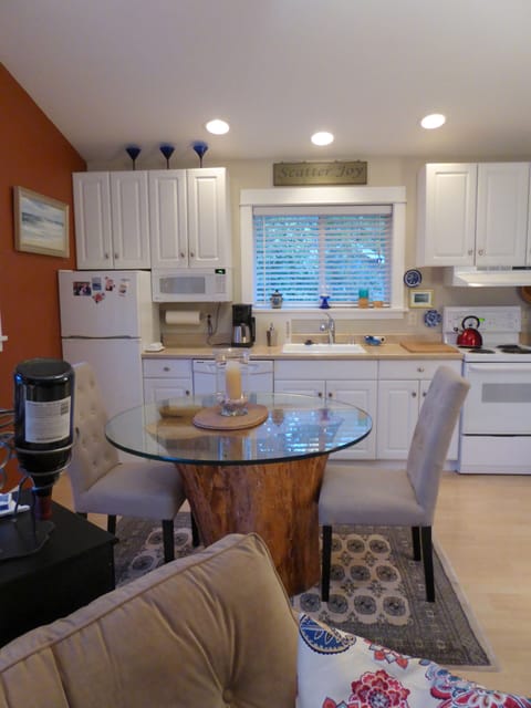 Dining table with glass top and tree trunk base with upholstered chairs
