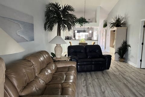 Reclining leather couch and love seat face TV and lanai