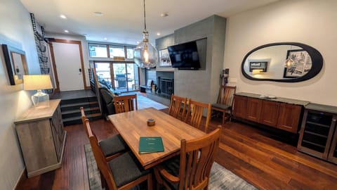 Living room with dining table, wood fireplace, and patio w/ propane BBQ grill