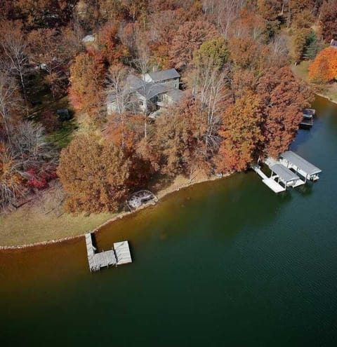 Aerial view showing house, 2 lots, both docks, and the sandy beach between them