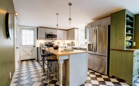 Open Plan Kitchen with Island with Vintage Stools, Refrigerator and Hutch