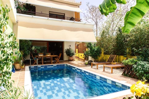 The exterior of the Villa, featuring the pool & the garden.