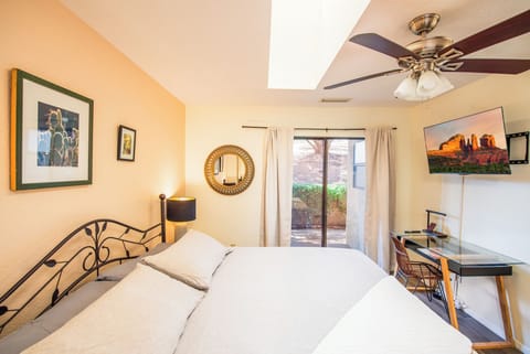 Peaceful primary bedroom with king bed, natural light, smart TV and patio access