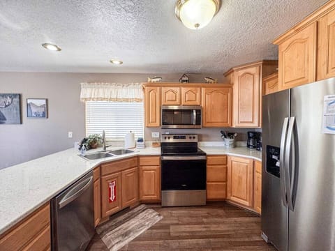 Charming, fully-equipped kitchen with natural wood cabinets and stainless steel appliances for effortless meals
