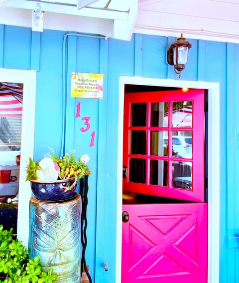 Welcome to the Beach Retreat, where a bold red Dutch door and a tiki sculpture add beach charm.
