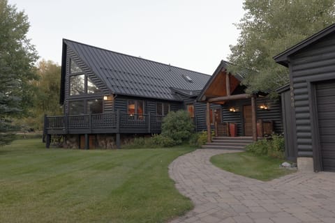 Step into your own mountain retreat, where rustic log charm meets modern comfort. This stunning property welcomes you with a winding stone pathway leading to warm, glowing windows that promise cozy evenings ahead.