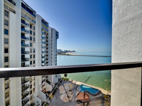 Balcony has view of the water and the pool.