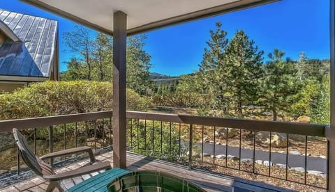 Relax on the private balcony with seating and peaceful views of surrounding trees and nature.