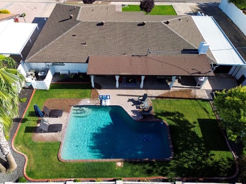Drone view of spacious backyard with comfortable seating and green space.