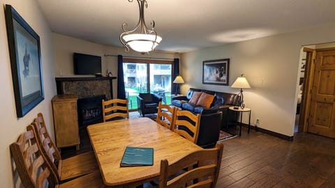 Living room with sofa bed, gas fireplace, dining table, and patio with gas BBQ