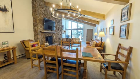 Living room with dining table, wood fireplace, and balcony with gas BBQ grill
