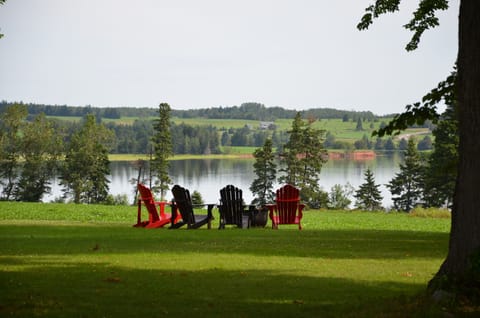 Peaceful scene as you pull up the driveway.  Adirondack chairs at fire pit.