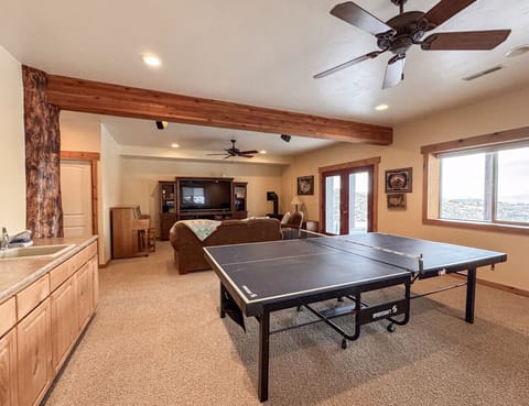Spacious basement game and media room with cozy seating, ping pong, and scenic views for relaxing fun