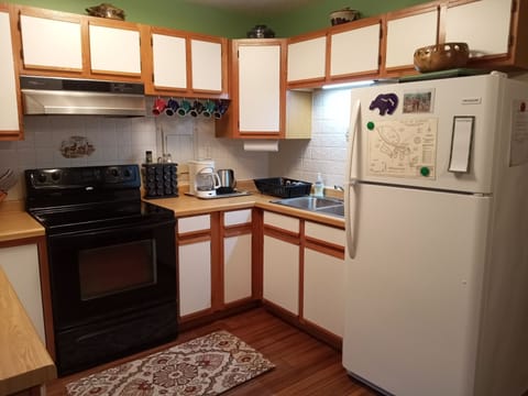Kitchen with full size electric range and refrigerator, coffee maker, hot pot