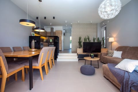 an open living system with dining table and 8 chairs, a living room and kitchen