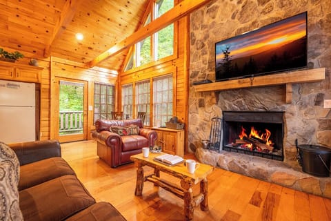 Cozy up in this stunning living room with vaulted wood ceilings, a crackling stone fireplace, and plush seating where you can unwind after a day of mountain adventures.