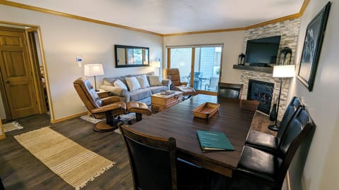 Living room with sofa bed, dining table, gas fireplace, and patio w/ propane BBQ