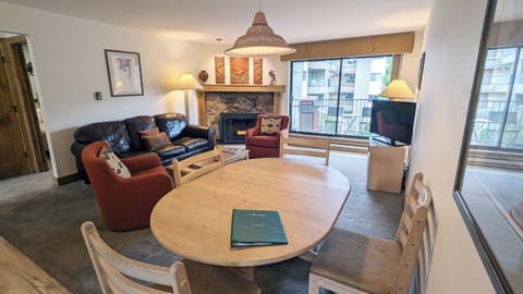 Living room with sofa bed, wood fireplace, and balcony w/ propane BBQ grill