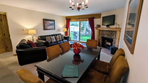 Living room with sofa bed, wood fireplace, dining table, and patio w/ gas BBQ
