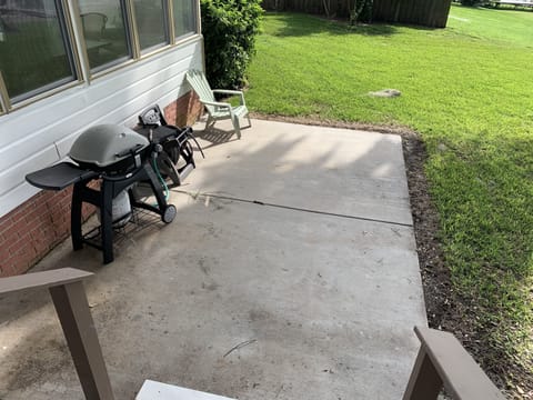Concrete patio w/ gas grille off back deck.