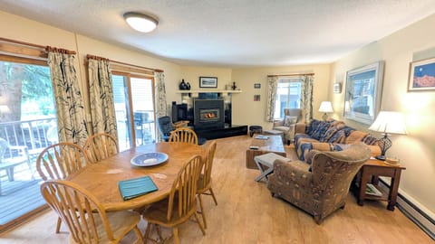 Living area w/ sofa bed, gas fireplace, dining table, and patio w/ gas BBQ grill