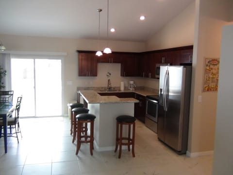 Kitchen with bartop and 4 bar chairs