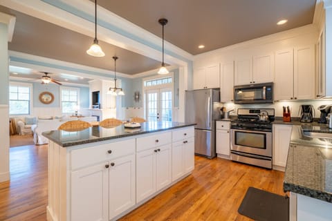 An open-concept chef`s kitchen featuring a large granite island—the perfect hub for morning coffee and conversation.